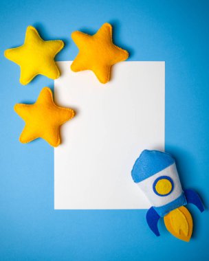 Roket çıkartıyor. El yapımı keçe oyuncak. Uzay gemisi Sundown arka plan üzerinde sarı yıldız.