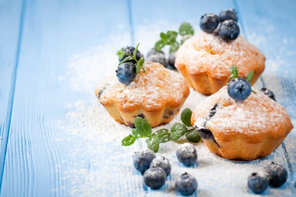 Yaban mersini, taze meyveler, mavi ahşap zemin üzerine nane, toz şeker ile ev yapımı Fırında kek. Üstten Görünüm.