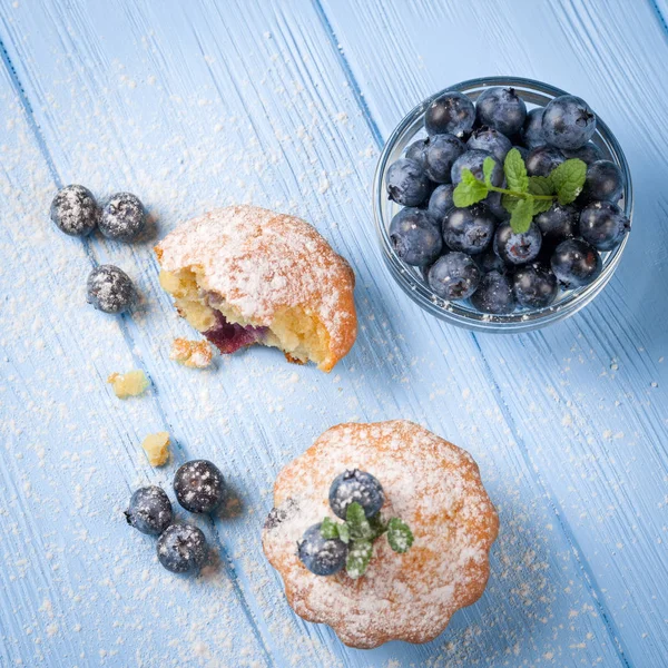 Yaban mersini, taze meyveler, mavi ahşap zemin üzerine nane, toz şeker ile ev yapımı Fırında kek. Üstten Görünüm.