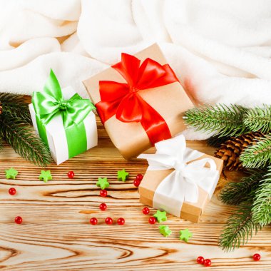 Ahşap arka plan üzerinde renkli şerit ve yay, yeşil Noel ağacı, Dekorasyon, beyaz ekose ile el sanatları Hediyelik kutu. Noel ve yeni yıl kutlama kartı, afiş, el ilanı.