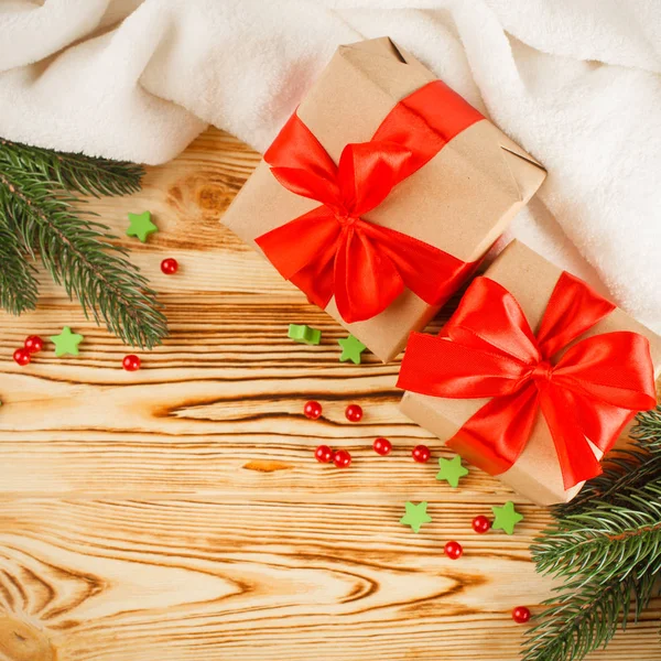 Cajas de regalo artesanales con cinta roja y lazo, árbol de Navidad verde, decoraciones, cuadros blancos sobre fondo de madera. Tarjeta de felicitación de Navidad y Año Nuevo, pancarta, volante . — Foto de Stock