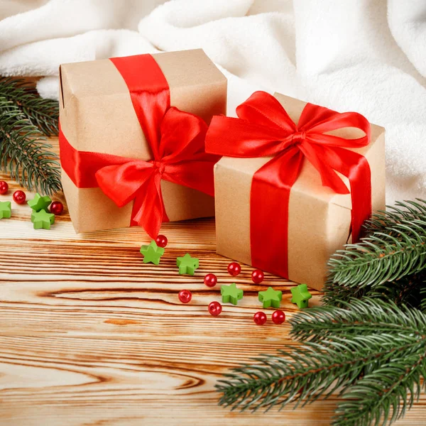 Cajas de regalo artesanales con cinta roja y lazo, árbol de Navidad verde, decoraciones, cuadros blancos sobre fondo de madera. Tarjeta de felicitación de Navidad y Año Nuevo, pancarta, volante . — Foto de Stock