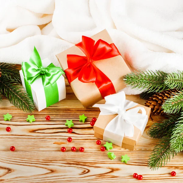 Ahşap arka plan üzerinde renkli şerit ve yay, yeşil Noel ağacı, Dekorasyon, beyaz ekose ile el sanatları Hediyelik kutu. Noel ve yeni yıl kutlama kartı, afiş, el ilanı.