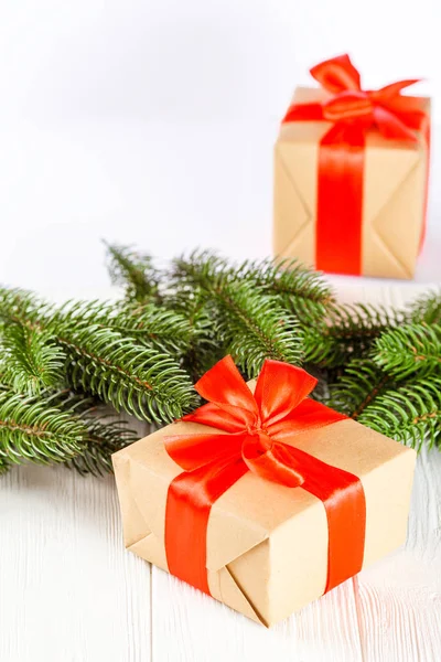 Cajas de regalo artesanales con cinta roja y lazo, árbol de Navidad verde, decoraciones, sobre fondo de madera blanca. Tarjeta de felicitación de Navidad y Año Nuevo, pancarta, volante . — Foto de Stock