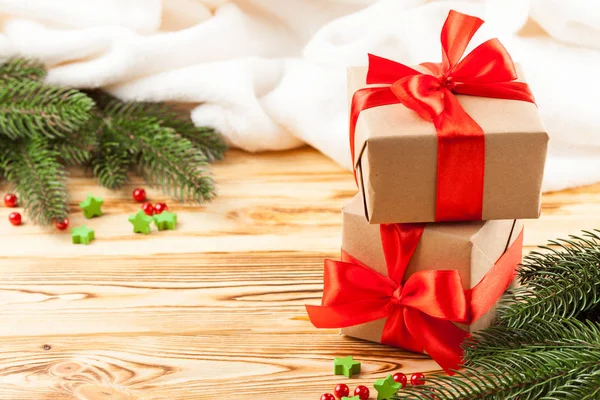 Cajas de regalo artesanales con cinta roja y lazo, árbol de Navidad verde, decoraciones, cuadros blancos sobre fondo de madera. Tarjeta de felicitación de Navidad y Año Nuevo, pancarta, volante . — Foto de Stock