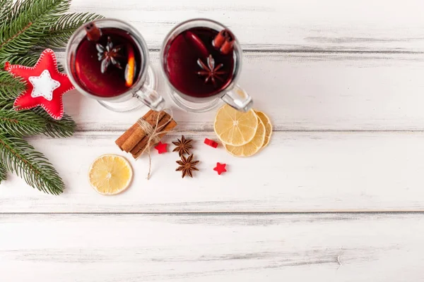 Bannière horizontale de vin chaud d'hiver. Lunettes avec vin rouge chaud et épices, arbre, feutre décorations sur fond bois . — Photo