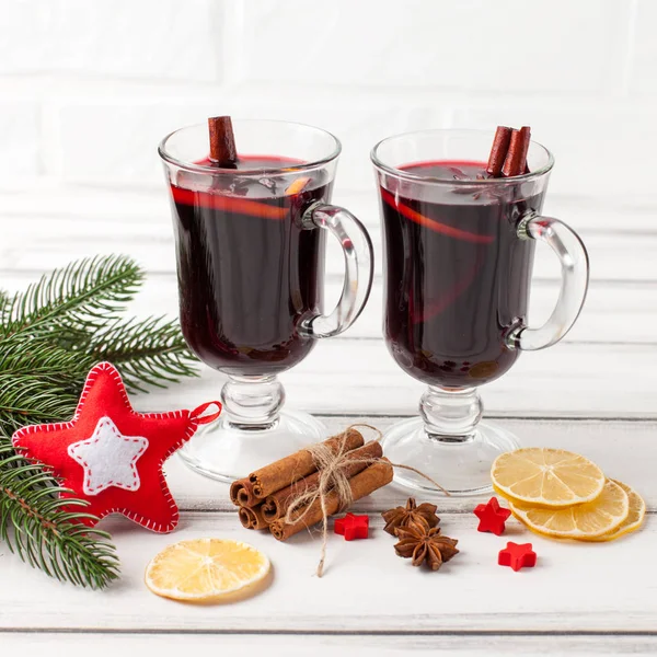 Bannière horizontale de vin chaud d'hiver. Lunettes avec vin rouge chaud et épices, arbre, feutre décorations sur fond bois . — Photo