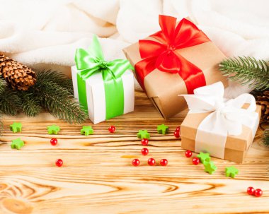 Ahşap arka plan üzerinde renkli şerit ve yay, yeşil Noel ağacı, Dekorasyon, beyaz ekose ile el sanatları Hediyelik kutu. Noel ve yeni yıl kutlama kartı, afiş, el ilanı.