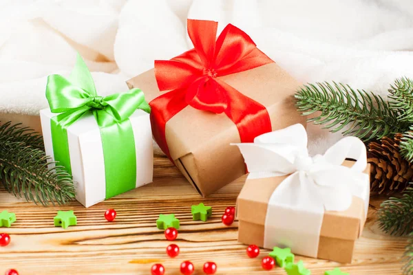 Cajas de regalo artesanales con cinta de color y lazo, árbol de Navidad verde, decoraciones, cuadros blancos sobre fondo de madera. Tarjeta de felicitación de Navidad y Año Nuevo, pancarta, volante . — Foto de Stock