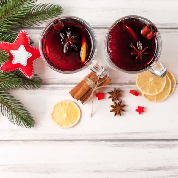 Kış yatay mulled şarap afiş. Gözlük sıcak kırmızı şarap ve baharat, ağaç, ahşap arka plan üzerinde keçe süslemeleri ile.