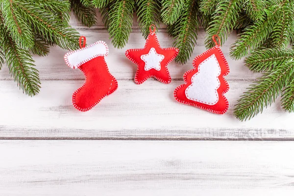 Banner de Navidad con árbol verde, conos, decoraciones de fieltro hechas a mano, naranja y canela sobre fondo de madera blanca. Espacio vacío para texto . — Foto de Stock