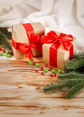 Ahşap arka plan üzerinde kırmızı kurdele ve yay, yeşil Noel ağacı, Dekorasyon, beyaz ekose ile el sanatları Hediyelik kutu. Noel ve yeni yıl kutlama kartı, afiş, el ilanı.