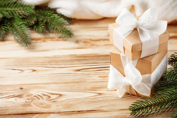 Cajas de regalo artesanales con cinta blanca, lazo, árbol de Navidad verde, decoraciones, cuadros blancos sobre fondo de madera. Tarjeta de felicitación de Navidad y Año Nuevo, pancarta, volante . — Foto de Stock