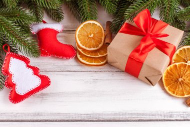 Yeşil ağaçlı, koniler, el yapımı yılbaşı banner süslemeleri, turuncu ve Beyaz ahşap zemin üzerine tarçın hissettim. Metin için boş yer.