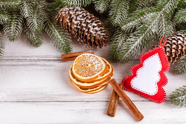 Banner de Navidad con árbol verde, conos, decoraciones de fieltro hechas a mano, naranja y canela sobre fondo de madera blanca. Espacio vacío para texto . — Foto de Stock