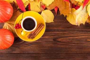 Sonbahar yatay afiş sarı ile kırmızı yaprakları, pumpkins, fincan kahve ve guelder gül kahverengi ahşap zemin üzerinde.