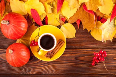 Sonbahar yatay afiş sarı ile kırmızı yaprakları, pumpkins, fincan kahve ve guelder gül kahverengi ahşap zemin üzerinde.