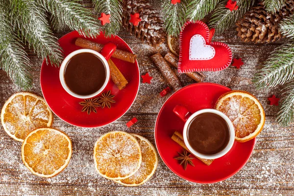 Bannière de Noël avec arbre vert, cônes, tasses rouges avec chocolat chaud, orange et cannelle sur fond en bois brun — Photo