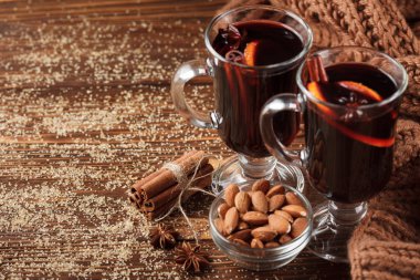 Kış yatay mulled şarap afiş. Sıcak kırmızı şarap ve baharat ahşap arka plan üzerinde gözlük.