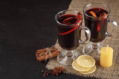 Mulled şarap afiş. Sıcak kırmızı şarap ve baharat koyu arka plan üzerinde gözlük. Modern karanlık ruh stili.