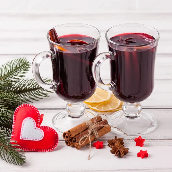 Bannière horizontale de vin chaud d'hiver. Lunettes avec vin rouge chaud et épices, arbre, feutre décorations sur fond bois . — Photo