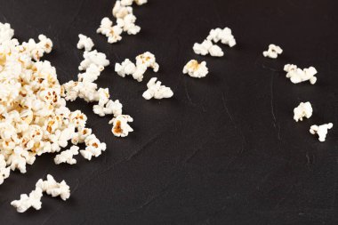 Patlamış mısır yatay banner. Kırmızı kağıt bardak ve koyu arka plan üzerinde yalan çekirdekleri elimden. Kopya alanı.