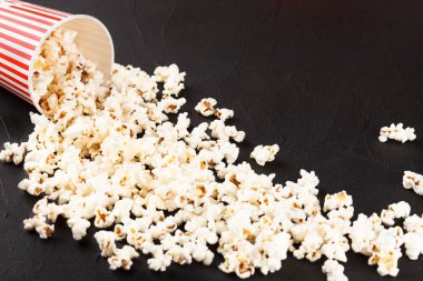 Patlamış mısır yatay banner. Kırmızı kağıt bardak ve koyu arka plan üzerinde yalan çekirdekleri elimden. Kopya alanı.