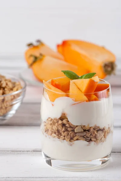 Kaki cremige Kleinigkeit in schönen Gläsern, frische reife Fruchtscheiben auf weißem Holzgrund. gesunde vegetarische Kost. leckeres Dessert. Nahaufnahmen. Selektiver Fokus. — Stockfoto