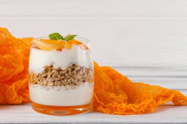 Trabzon hurması kremalı pasta ister güzel gözlük, taze olgun meyve dilimleri Beyaz ahşap zemin üzerinde. Sağlıklı vejetaryen yemek. Lezzetli tatlı. Fotoğraf kadar kapatın. Seçici odak.