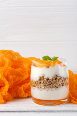 Trabzon hurması kremalı pasta ister güzel gözlük, taze olgun meyve dilimleri Beyaz ahşap zemin üzerinde. Sağlıklı vejetaryen yemek. Lezzetli tatlı. Fotoğraf kadar kapatın. Seçici odak.