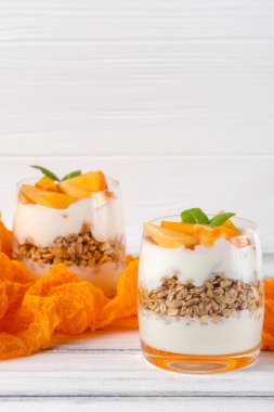 Trabzon hurması kremalı pasta ister güzel gözlük, taze olgun meyve dilimleri Beyaz ahşap zemin üzerinde. Sağlıklı vejetaryen yemek. Lezzetli tatlı. Fotoğraf kadar kapatın. Seçici odak.