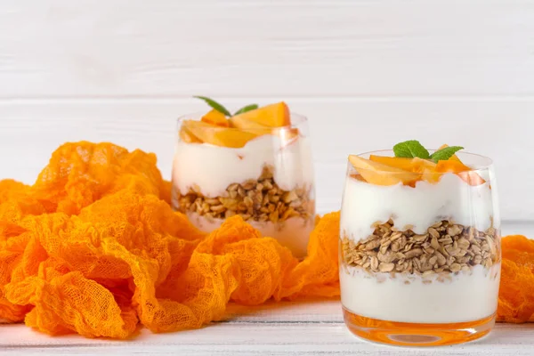 Trabzon hurması kremalı pasta ister güzel gözlük, taze olgun meyve dilimleri Beyaz ahşap zemin üzerinde. Sağlıklı vejetaryen yemek. Lezzetli tatlı. Fotoğraf kadar kapatın. Seçici odak.