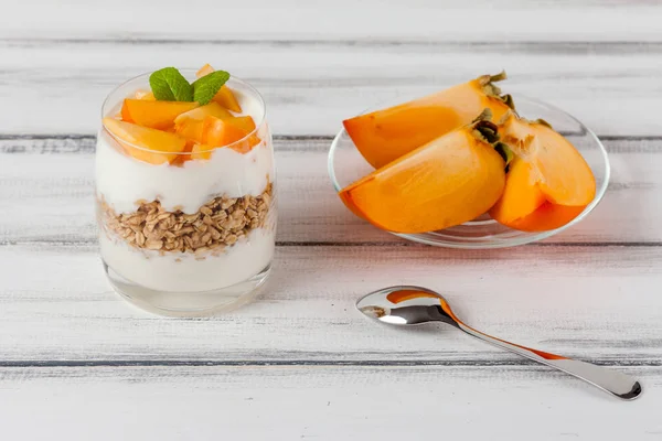 Kaki cremige Kleinigkeit in schönen Gläsern, frische reife Fruchtscheiben auf weißem Holzgrund. gesunde vegetarische Kost. leckeres Dessert. Nahaufnahmen. Selektiver Fokus. — Stockfoto