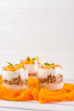 Trabzon hurması kremalı pasta ister güzel gözlük, taze olgun meyve dilimleri Beyaz ahşap zemin üzerinde. Sağlıklı vejetaryen yemek. Lezzetli tatlı. Fotoğraf kadar kapatın. Seçici odak.