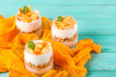 Trabzon hurması kremalı pasta ister güzel gözlük, nane ahşap arka plan taze olgun meyve dilimleri. Sağlıklı vejetaryen yemek. Lezzetli tatlı. Fotoğraf kadar kapatın. Seçici odak.