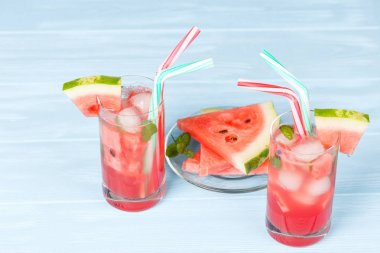 Buz ve nane yaprakları ile karpuz limonata. Ev yapımı limonata kırmızı ve yeşil ripes ile olgun Berry. Soğuk karpuz çay bardak. Canlandırıcı yaz içeceği. Ahşap arka plan üzerinde kokteyl