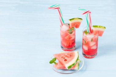 Buz ve nane yaprakları ile karpuz limonata. Ev yapımı limonata kırmızı ve yeşil ripes ile olgun Berry. Soğuk karpuz çay bardak. Canlandırıcı yaz içeceği. Ahşap arka plan üzerinde kokteyl