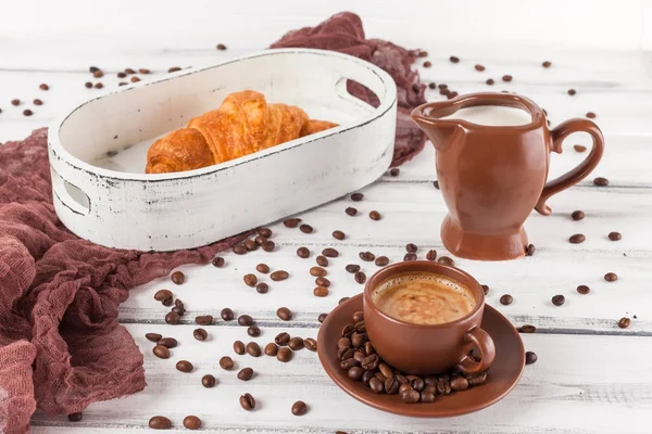 Freshly baked croissants on brown napkin, cream, to cups of coffee in ceramic dishes on white wooden background. Fresh pastries for breakfast. Delicious dessert. Closeup photography.Horizontal banner — Stock Photo, Image