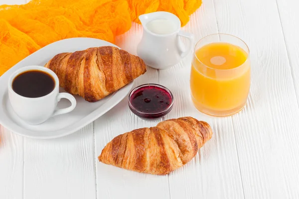 French breakfast with croissant, berries, jam and black coffee