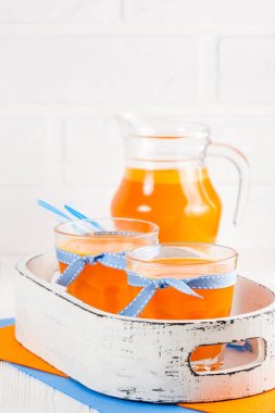 Güzel gözlük ve sürahi beyaz ahşap zemin üzerinde olgun sebze parçaları ile kabak taze meyve suyu. Tatlı portakal suyu. Sağlıklı beslenme, diyet Tema. Fotoğraf kadar kapatın. Dikey başlık