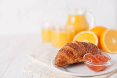 Fırından yeni çıkmış kruvasan, portakal suyu, taze meyve, Beyaz ahşap arka plan üzerinde reçel. Fransız kahvaltı. Taze hamur işleri sabah için. Lezzetli tatlı. Portre fotoğrafçılığı. Yatay başlık