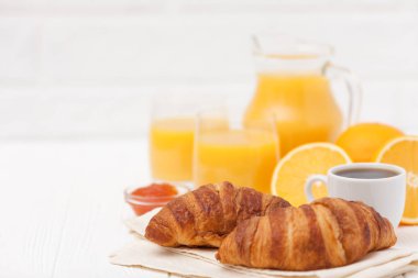 Taze pişmiş kruvasan, portakal suyu, taze meyve, kahve Beyaz ahşap zemin üzerinde. Fransız kahvaltı. Taze hamur işleri sabah için. Lezzetli tatlı. Portre fotoğrafçılığı. Yatay başlık