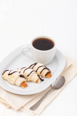 Fırından yeni çıkmış kruvasan, reçel, Beyaz ahşap zemin üzerinde siyah kahve. Ev yapımı kurabiye. Kahvaltı için taze hamur işleri. Lezzetli tatlı. Portre fotoğrafçılığı. Yatay başlık