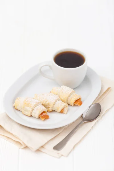 Freshly baked croissant, jam, cup of black coffee on white wooden background. Homemade cookie. Fresh pastries for breakfast. Delicious dessert. Closeup photography. Horizontal banner — Stock Photo, Image