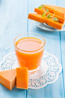 Güzel gözlük ve sürahi beyaz ahşap zemin üzerinde olgun sebze parçaları ile kabak taze meyve suyu. Tatlı portakal suyu. Sağlıklı beslenme, diyet Tema. Fotoğraf kadar kapatın. Dikey başlık