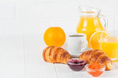 Fırından yeni çıkmış kruvasan, portakal suyu, taze meyve, Beyaz ahşap arka plan üzerinde reçel. Fransız kahvaltı. Taze hamur işleri sabah için. Lezzetli tatlı. Portre fotoğrafçılığı. Yatay başlık
