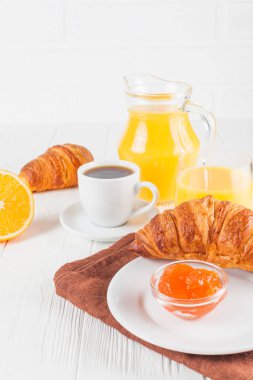 Fırından yeni çıkmış kruvasan, portakal suyu, taze meyve, Beyaz ahşap arka plan üzerinde reçel. Fransız kahvaltı. Taze hamur işleri sabah için. Lezzetli tatlı. Portre fotoğrafçılığı. Dikey başlık