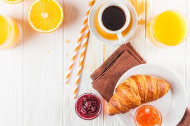 Fırından yeni çıkmış kruvasan, portakal suyu, taze meyve, Beyaz ahşap arka plan üzerinde reçel. Fransız kahvaltı. Taze hamur işleri sabah için. Lezzetli tatlı. Portre fotoğrafçılığı. Yatay başlık