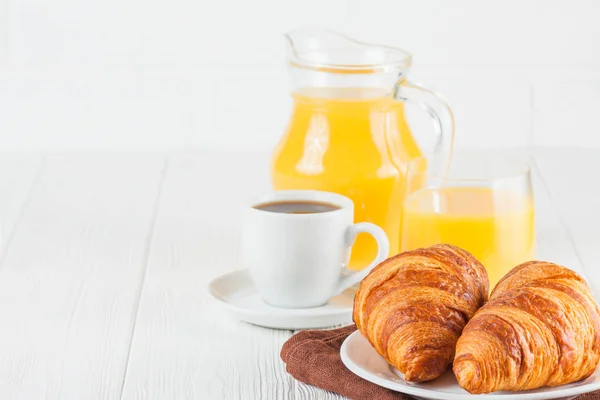 Свежеиспеченные круассаны, апельсиновый сок, свежие фрукты, варенье на белом деревянном фоне. Французский завтрак. Свежая выпечка на утро. Вкусный десерт. Фотография крупным планом. Горизонтальное знамя — стоковое фото