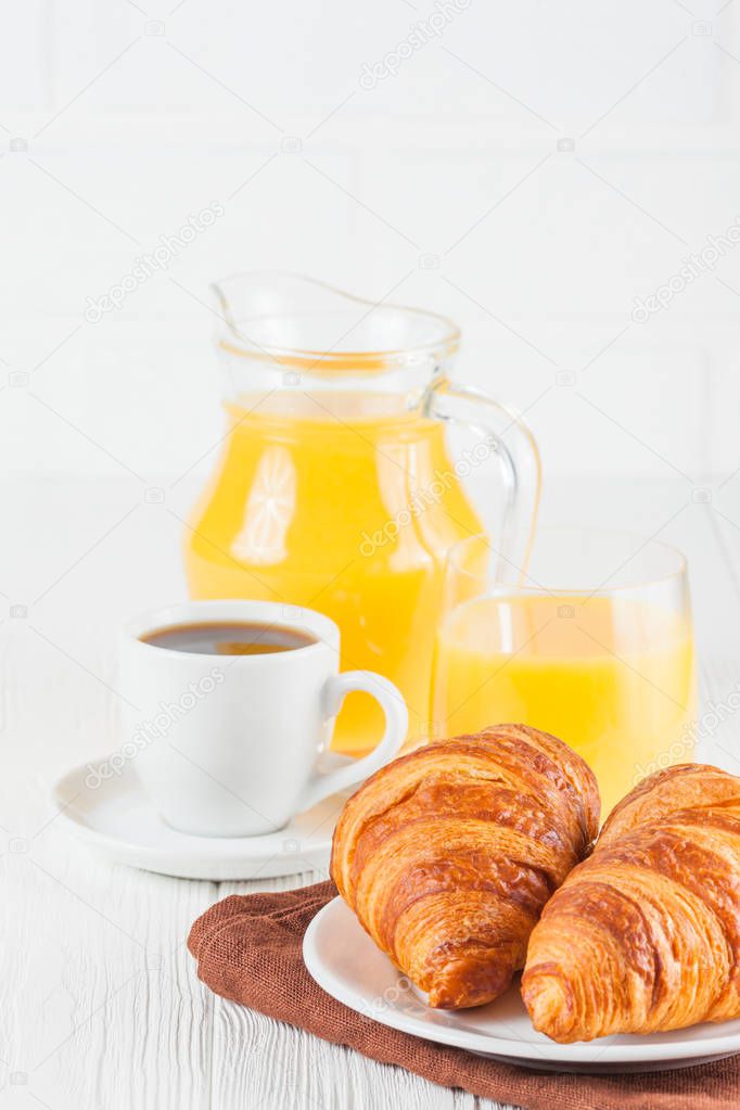 Freshly baked croissant, orange juice, fresh fruits, jam on white wooden background. French breakfast. Fresh pastries for morning. Delicious dessert. Closeup photography. Vertical banner